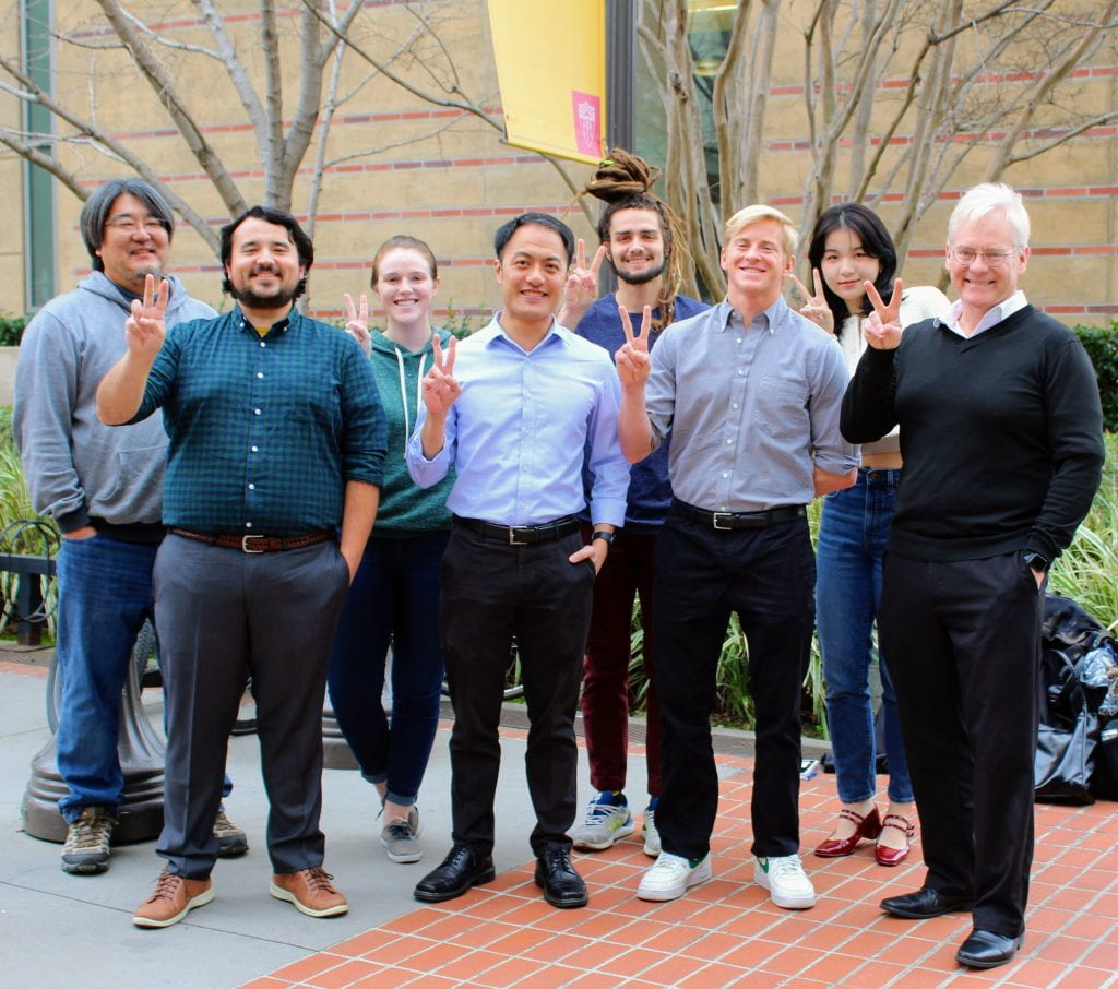 Group photo of lab with two fingers up for "Fight On"